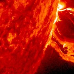 A portion of the sun and from its limp a u shaped cme stretching out like a scarf in the wind