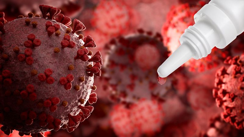 white dropper bottle in top right hand corner of image, against backdrop of red 3D-rendered coronaviruses
