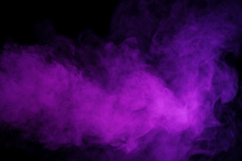 Purple smoke drifting on a black background, looking moody and dramatic 