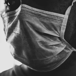 black and white close up photo of person wearing a white disposable mask