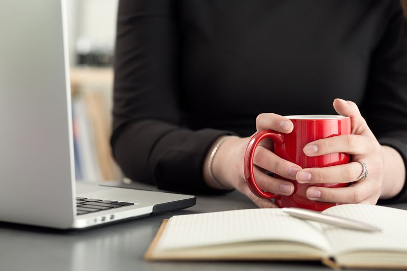 close up of a person holding onto a mug