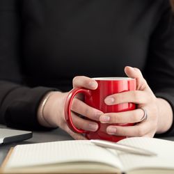 close up of a person holding onto a mug