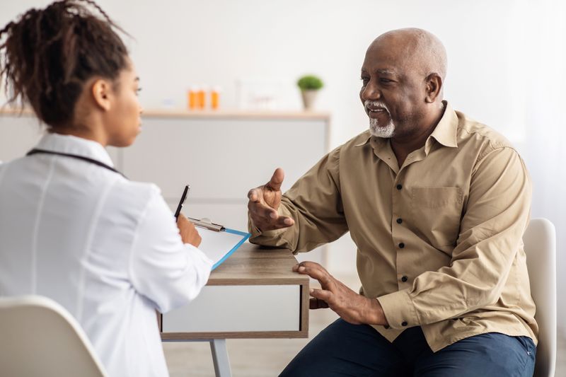 older adult man in medical consultation with younger female doctor