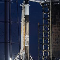 The rocket is seen at night on the launch pad. It is clear and well illumindated. 
