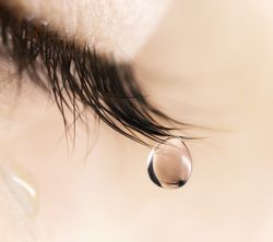 closeup of teardrop falling from someone's eye