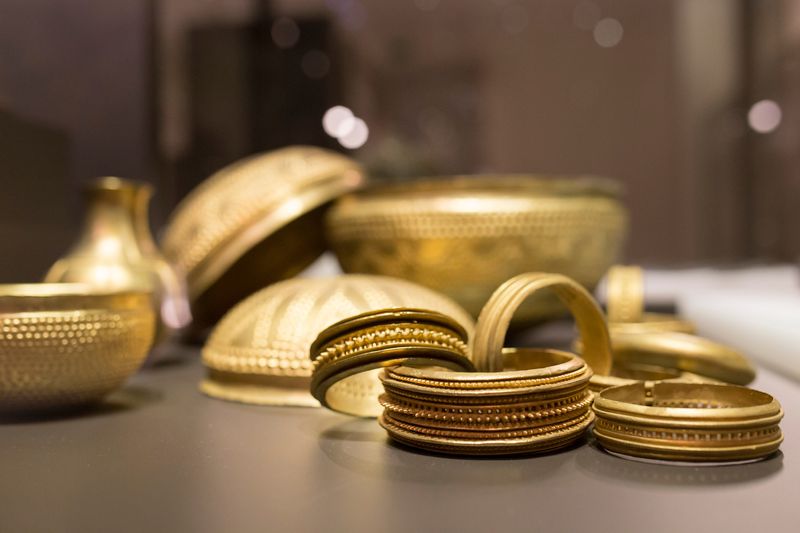 gold coloured bangles and bowls lying on a table
