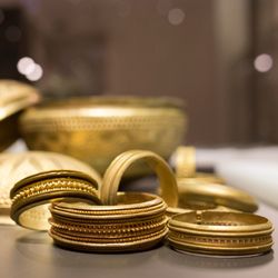gold coloured bangles and bowls lying on a table