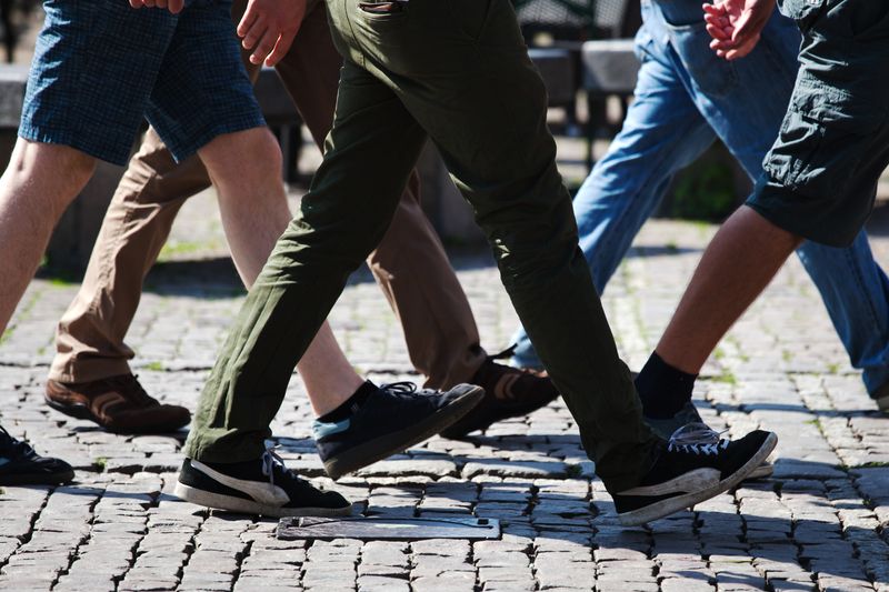 The legs of several people walking.