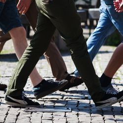 The legs of several people walking.