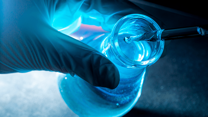 A flask containing a shiny blue liquid.