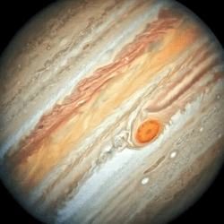 Jupiter seeing at an angle by Hubble. Its bands of latitudinally parallel weather are clearly visible and in the middle but slightly south, there is the great red spot