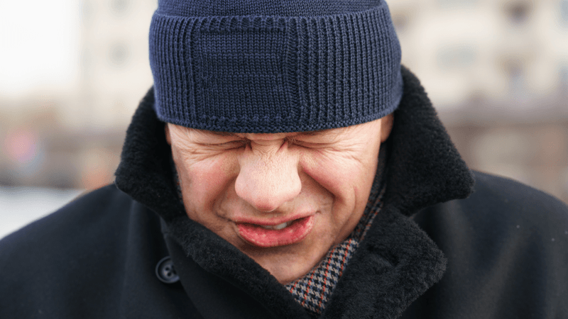 man trying to hold in a sneeze