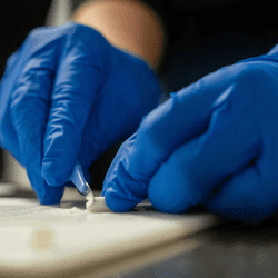 A sample of some clumped powder is taken for testing at the CanTEST facility