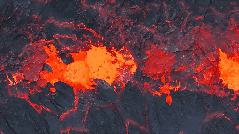 Close up drone shot of lava bubbling. Bright orange and red colors.
