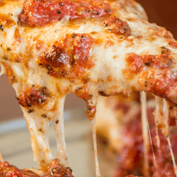 a slice of pizza with melted cheese oozing of the edges
