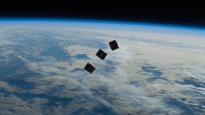 Three cubesats above Earth.