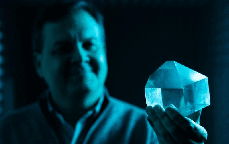 Professor Peter Vekilov holding up a crystal after having explained the process by which crystals grow from solutions.