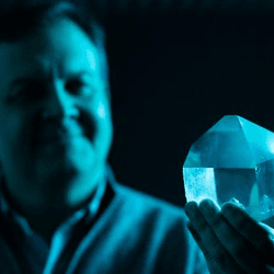 Professor Peter Vekilov holding up a crystal after having explained the process by which crystals grow from solutions.
